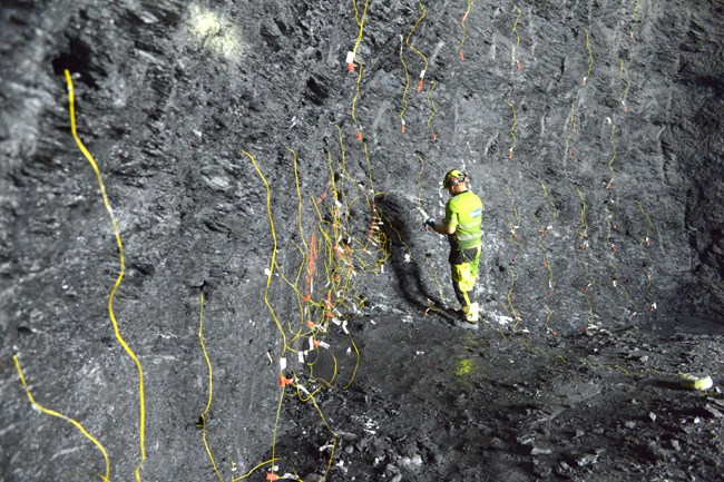 Preparing the tunnel face with connections to the detonators for a drill and blast round