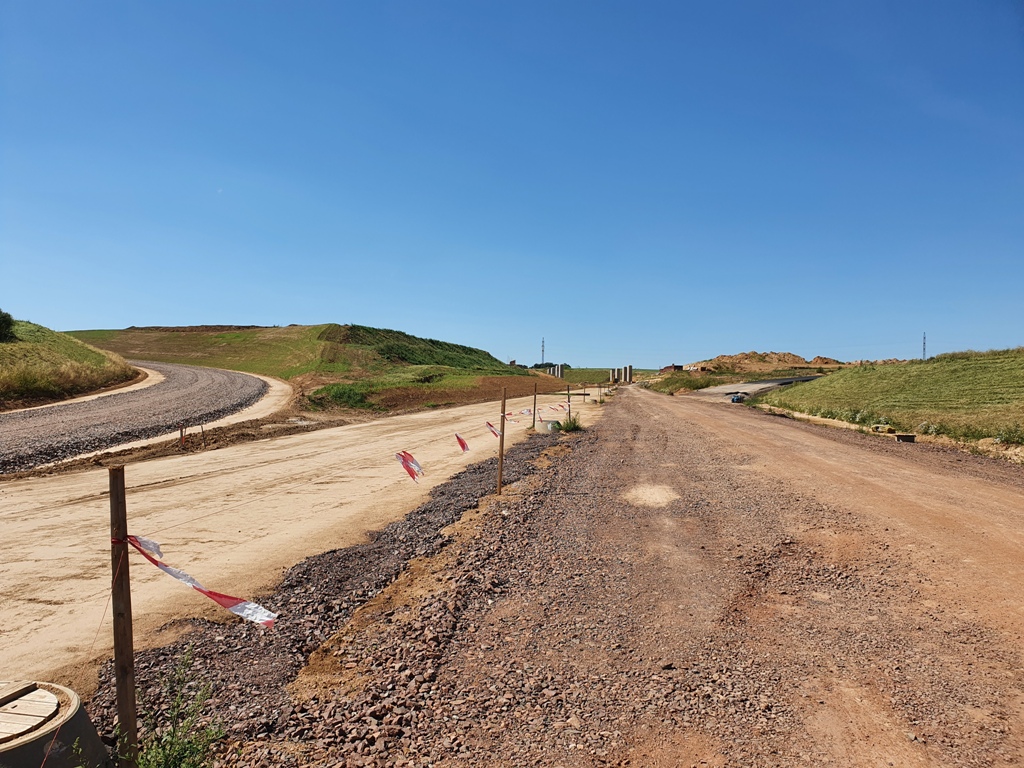 MUK Jaroměř sever, za fotografem je směr Náchod, doprava vyasfaltovaná rampa směr PL, rovně pilíře dáničního mostu, pravý pás vede směr Praha, levý pás je odpojení ve směru PL - Náchod, a zcela vlevo odpojovací rampa pro směr Praha - Náchod.