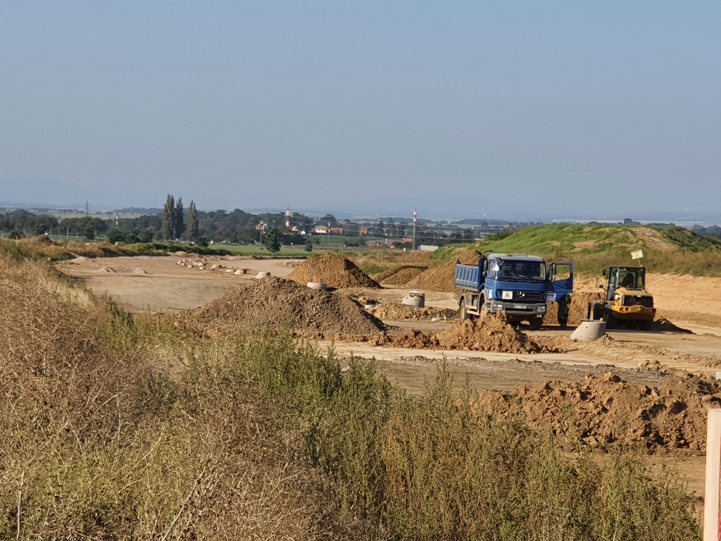 Z kopečku nad Svobodnými Dvory směrem ke křižovatce s I/35, křižovatka začíná hned za zatáčkou, pohled je ve směru na PL.