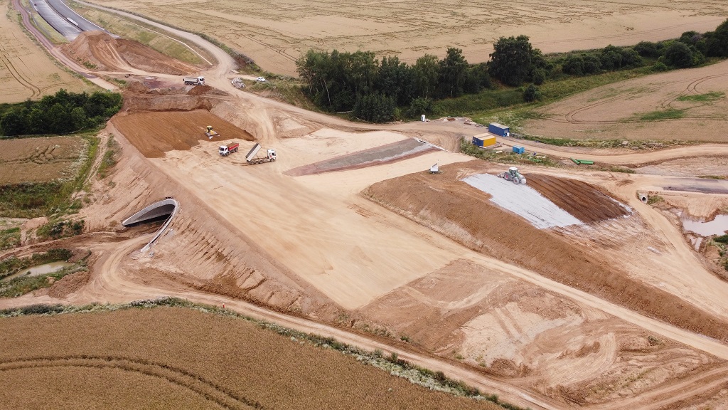 Vrstvení náspu přes podjezd polní cesty. Směr Hradec Králové.