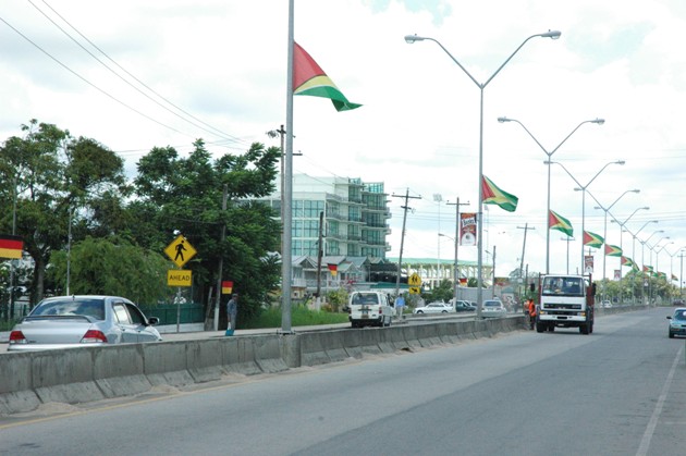 Guyana flags mounted on East Bank Demerara four-lane highway.JPG