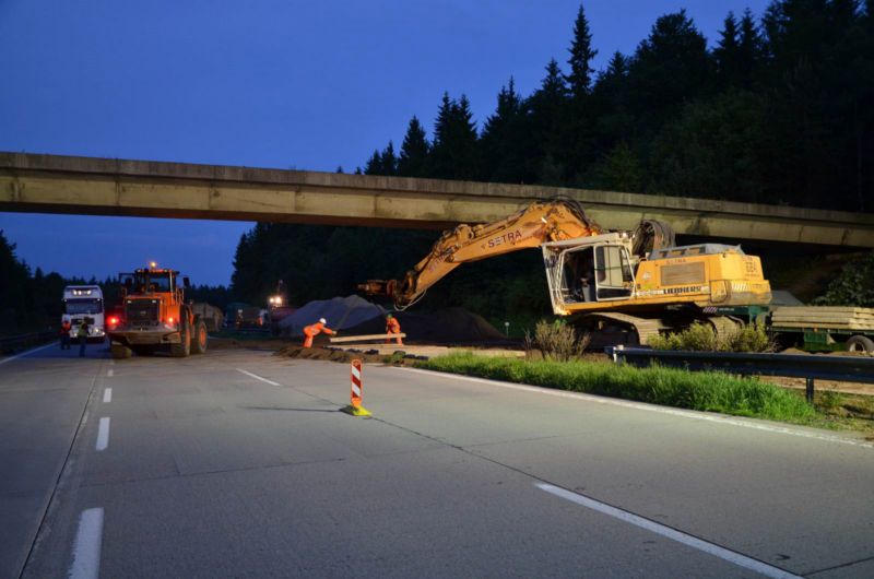 Dělníci umisťují do středního dělícího pasu betonové panely pro ochranu v něm umístěných inženýrských sítí